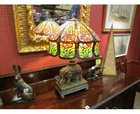 A Tiffany style figural table lamp multi coloured glass shade with elephant platform base, ball feet. Shade 40cms diameter ov