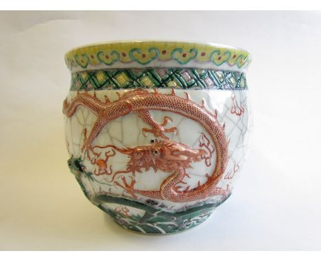 A 19th Century Chinese jardiniere with high relief dragons chasing a pearl, enamel detailing double concentric circle mark to