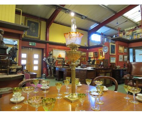 A Victorian oil lamp with etched frilled peach tint glass shade depicting birds in flowering branches over a fluted brass res