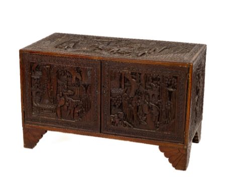 A carved Chinese camphor-wood Chest, c. 1900, the top carved profusely with a Chinese battle scene with warriors on horse bac