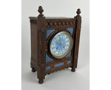 An Aesthetic movement oak striking Mantel Clock, in the Gothic manner with acorn finials and a blue and white porcelain dial 