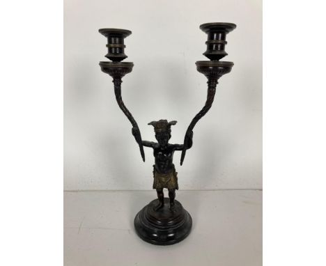 A bronze Candelabrum,&nbsp;modelled as an Aboriginal Young Man holding two spiral reeded candle arms, in the Directoire style