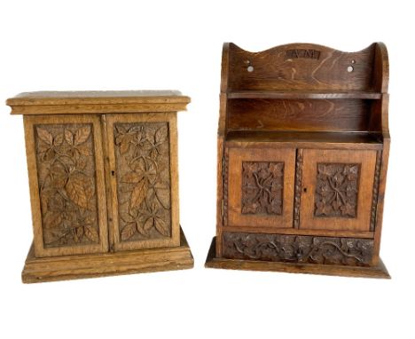 A carved oak Smokers Companion&nbsp;(wall mounting), with shaped pipe rack above two carved ivy leaf doors and a base drawer,