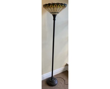 A tall bronzed Tiffany style Floor or Standard Lamp, with upward lighting stained glass shade on a two stage reeded stem and 