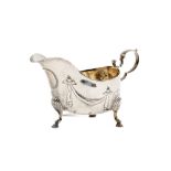 An Irish silver Sauceboat, embossed with hanging drapes and hammered bead work on S shell legs and