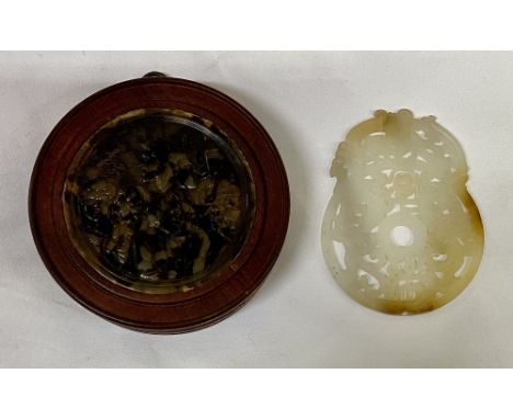 A Chinese carved and pierced jade Dish, with two stylized dragons, 10cms (3 3/4"); together with a circular mahogany Frame in