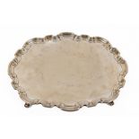 A large heavy oval silver Tray, with shaped pie crust edge on four scroll legs by Atkin Brothers,