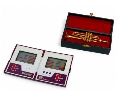 A retro Mario Bros Game & Watch dual screen handheld game, together with a cased gilt metal trumpet, 12cm long. (2)Game untes