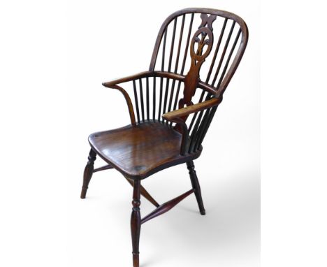 A 19th century ash and elm stick back Windsor elbow chair, with a fleur de lys splat, 47 by 56 by 96cm high.