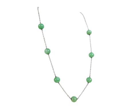 A jade and seed pearl necklace 43cm long, the jade roundels 8.8mm diameter.