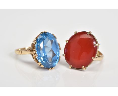 TWO LARGE GEMSTONE RINGS, the first designed with a large oval cut carnelian panel within an eight claw setting, to the trifu