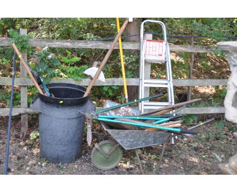 A COLLECTION OF VINTAGE GARDEN TOOLS, including a plastic dustbin, a wheelbarrow, rakes, spades, forks, hoes, aluminium steps