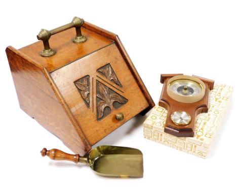 A late Victorian oak coal box, the hinged lid with carved leaf decoration, brass handle and brass scoop with turned treen han