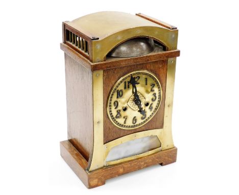 An early 20thC Art Nouveau oak and brass cased mantel clock for Liberty and Co, circular brass dial bearing Arabic numerals, 