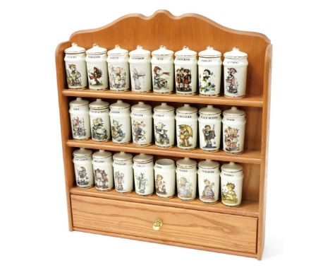 A Goebel pottery collection of herb and spice jars, decorated with various Hummel figures and description of contents, in a w