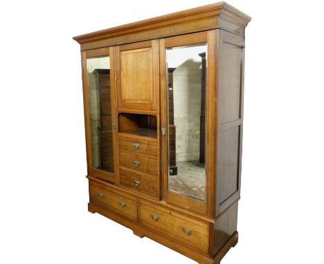 A Victorian oak compactum wardrobe, the out swept pediment over a central door enclosing a single shelf, above a recess and t