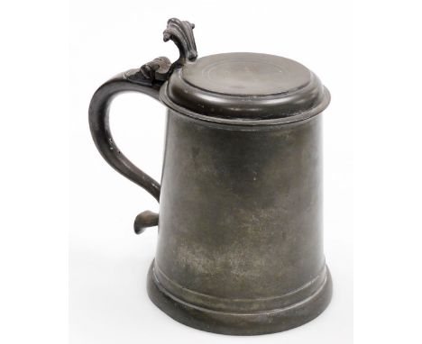 A pewter flat lid quart tankard, possibly Charles II period, with a scrolling handle, terminating in a bifurcated rams horn h