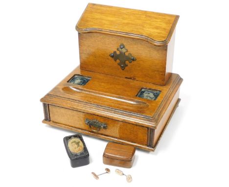 A Victorian oak desk stand, the three section stationary rack with a hinged shaped lid, base with inkwell and pen recesses, o