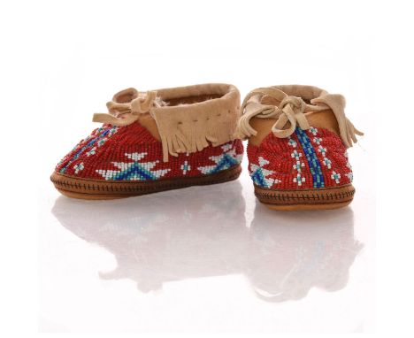 Soft hide. Profuse bead decoration in Native geometric designs.A vintage infant's pair of Native American soft leather hide m