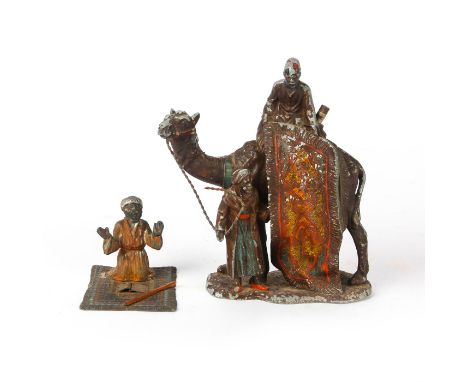 2 detailed painted metal alloy figures.One figure is of a bearded man on prayer rug. The other figure is of a man on a camel 