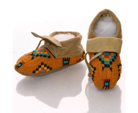 Soft hide. Profuse bead decoration in Native geometric designs.A vintage child's pair of Native American soft leather hide mo