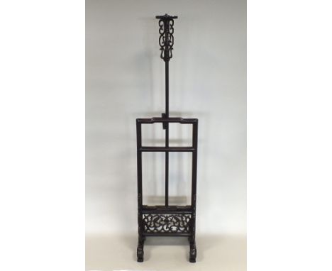 A Chinese hardwood adjustable lamp stand, early 20th century, the shallow humpback form top frame supported on vertical sides
