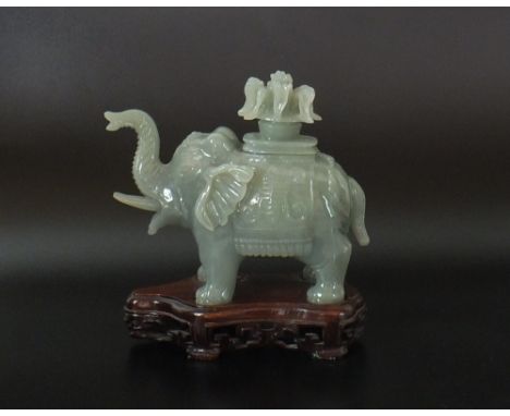 A Chinese carved mutton fat jade elephant form box and cover, 20th century, of even celadon tone, modelled standing with trun