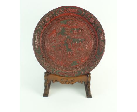 A Chinese two colour cinnabar lacquer tray and hard wood stand, Qianlong Period (1735-1796), of circular form with pronounced