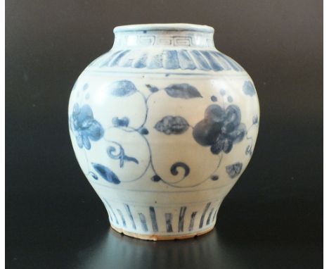 A Chinese blue and white jar, Ming Dynasty, of squat baluster form, decorated in provincial style with a stylised floral desi