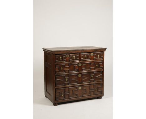 A CHARLES II OAK CHEST OF DRAWERS with three plank moulded top, above two short and three long graduated drawers, with archit