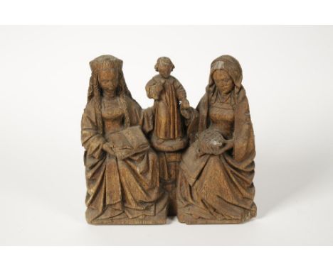 A CARVED OAK ARCHITECTURAL FRAGMENT with the Christ Child to the centre flanked by The Virgin Mary and another seated female 