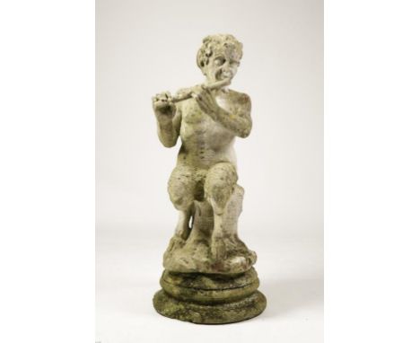 A RECONSTITUTED STONE GARDEN ORNAMENT in the form of a seated figure of Pan playing the pipes, on a circular base, 48" high. 