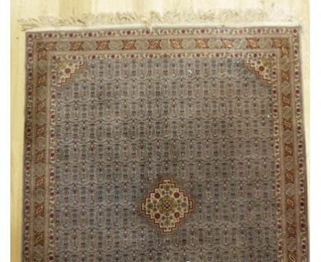 A PERISAN RUG with a central diamond motif within a pale blue surround with all over repeated stylised motifs within a multig