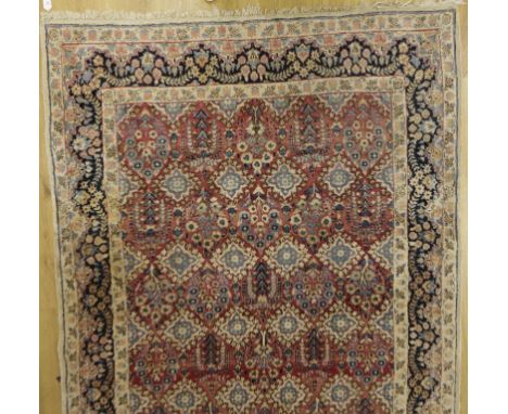 A NORTH WEST PERSIAN CARPET, the central panel worked with repeated foliate and geometric motifs against a pale red ground wi