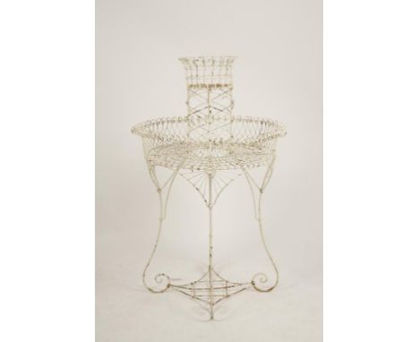 A VICTORIAN WIREWORK PLANTER of circular form with a central rising column surrounded by a broad trough, on scrolling legs wi