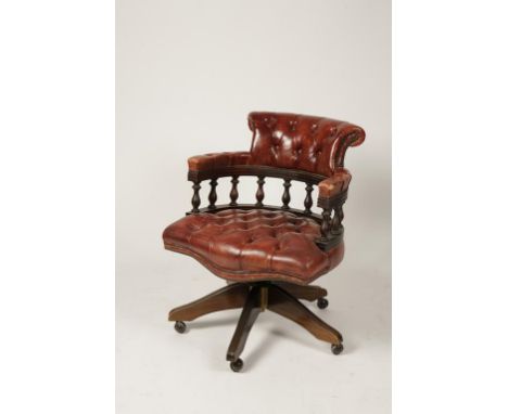 A VICTORIAN STYLE CAPTAINS SWIVEL DESK CHAIR with red button back upholstery, on five splayed legs with castors, 33" high. Pr