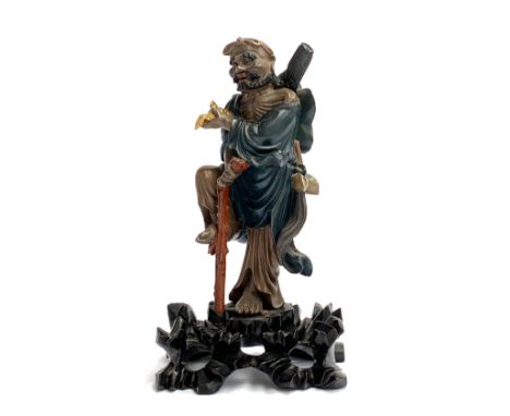 A Chinese carved polychrome wood figure of an ascetic monk, modelled holding a gilt bird, on a pierced base, 26.5cmH, with a 