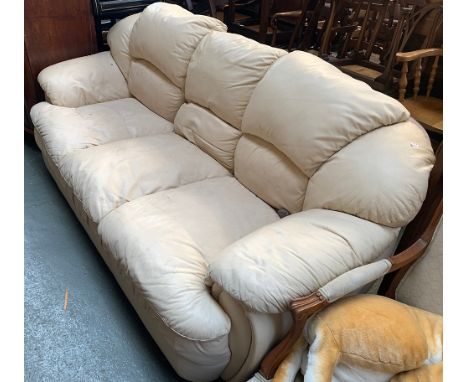 A cream vinyl three seater sofa 