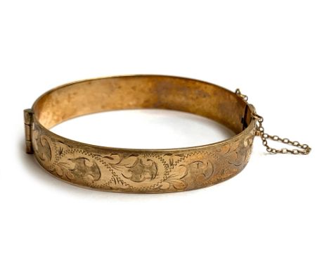 A 1/5 9ct rolled gold foliate engraved bangle, with safety chain, 6.6cmW, approx. 44.7g 