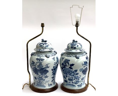 A large pair of decorative blue and white Chinese lidded urns, each on turned wood stand with gilt metal light fitting, the v