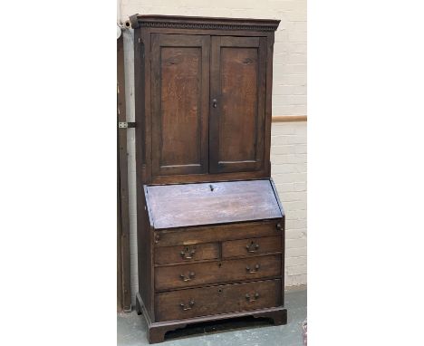 An 18th century oak bureau bookcase, the top with two fielded panel doors, the fall front opening to a fitted interior with w