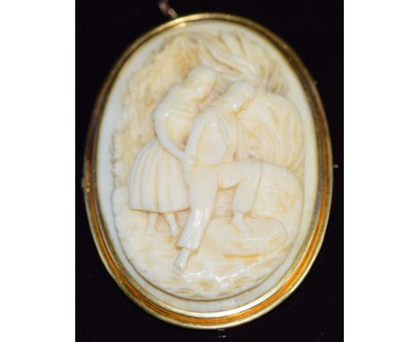 A c1900 yellow metal brooch set with an carved ivory cameo of a young couple, 5 x 3.5cm