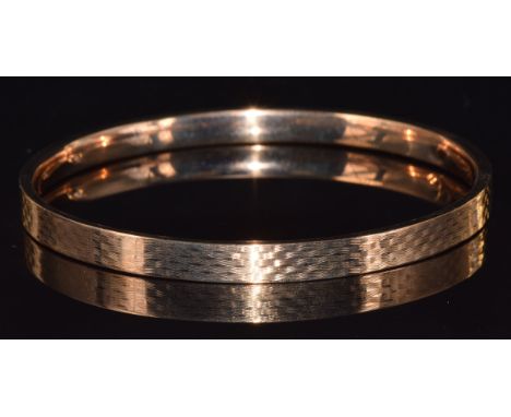 A 9ct gold flapper bangle with engine turned decoration, 9.7g