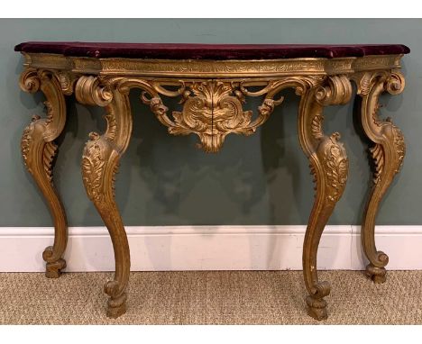 18TH C. ITALIAN CARVED GILTWOOD CONSOLE STAND, in the high rococo taste, mauve velvet covered top standing on four foliate ca