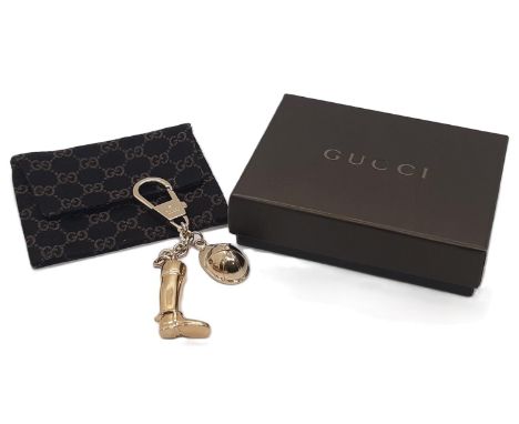 Gucci  keyring featuring a riding boot and hat in gold metalwork with monogrammed cloth bag and box. Unused. 