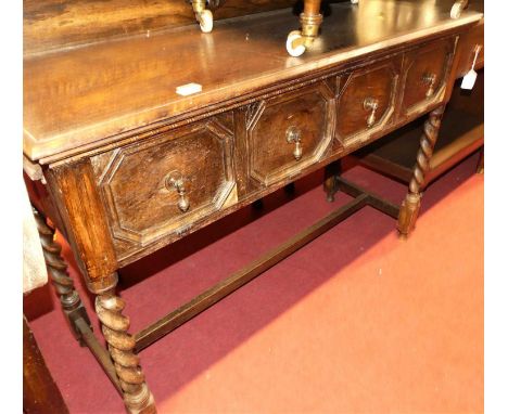 An early 20th century oak ledgeback side table, having twin hinged compartments enclosing four drawers, width 111cm