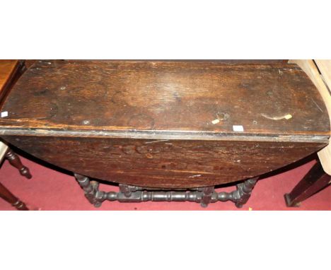 An 18th century joined oak dropleaf dining table, raised on turned and square cut supports