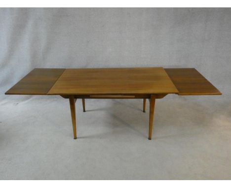 A mid century vintage teak extending dining table with unusual patent rise and fall winding action. H.71 (maximum height) H.6