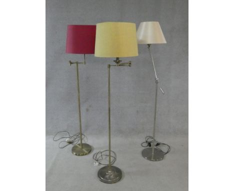 Two brass standard lamps with articulated actions and a chrome adjustable standard lamp. H.162cm 