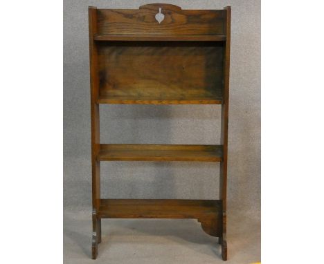 An vintage oak open bookcase with fret cut decoration on platform feet. H.116 W.62 D.23cm 
